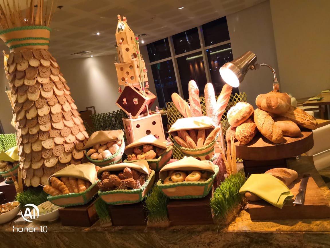 Bread buffet display with baskets and a tall centerpiece