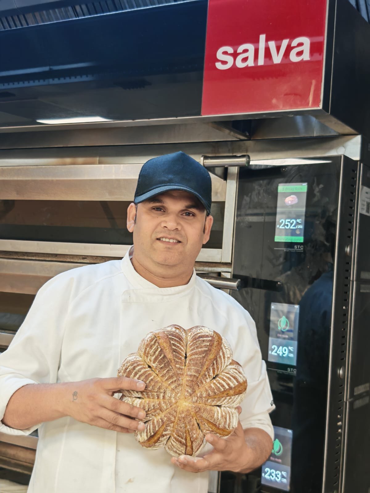 Narendra Singh in chef uniform holding an artisan loaf